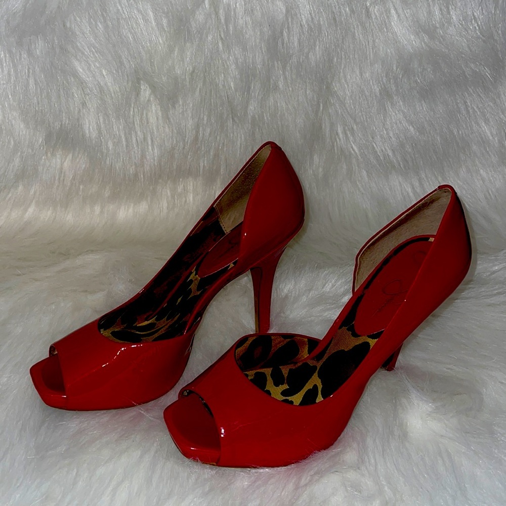 A pair of red, patent leather, open toed heels.